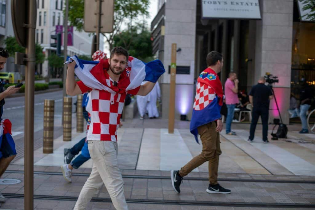 Croatian soccer fans celebrating with flags in the streets of Doha, Qatar during the World Cup.