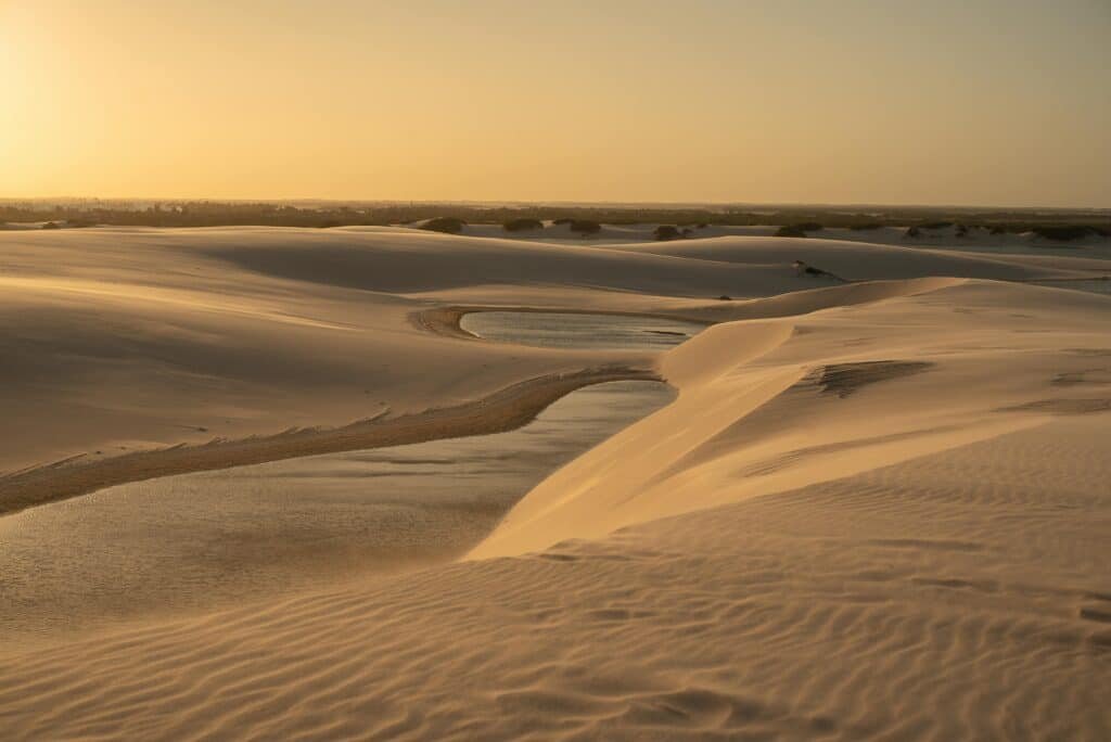 Golden sunset over tranquil sand dunes in Brazil's stunning landscape.