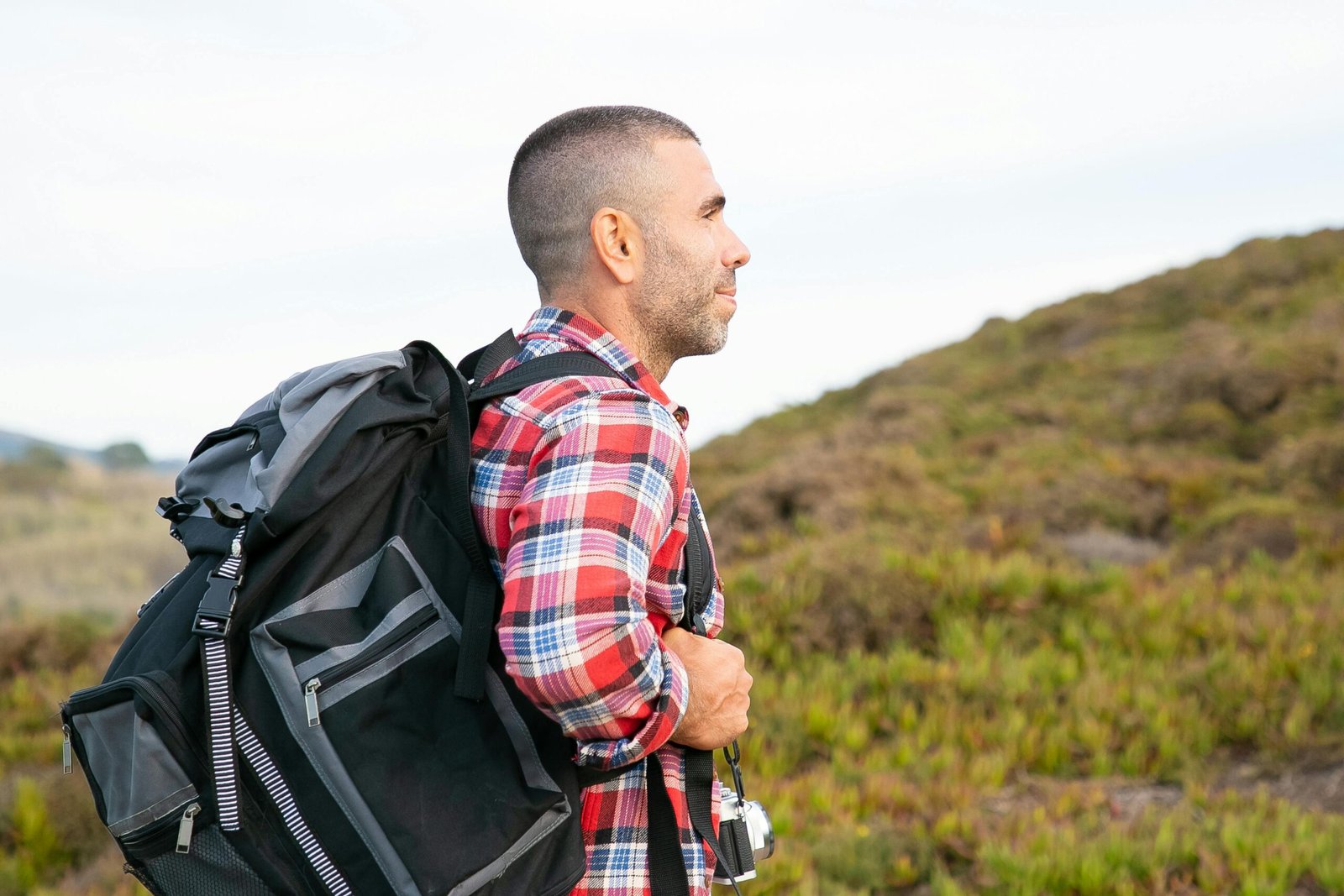 Home Side view of a male hiker in plaid shirt exploring the lush countryside of Portugal.